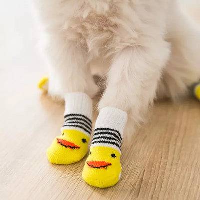 chausson chat canard jaune et blanc porté par un chat blanc